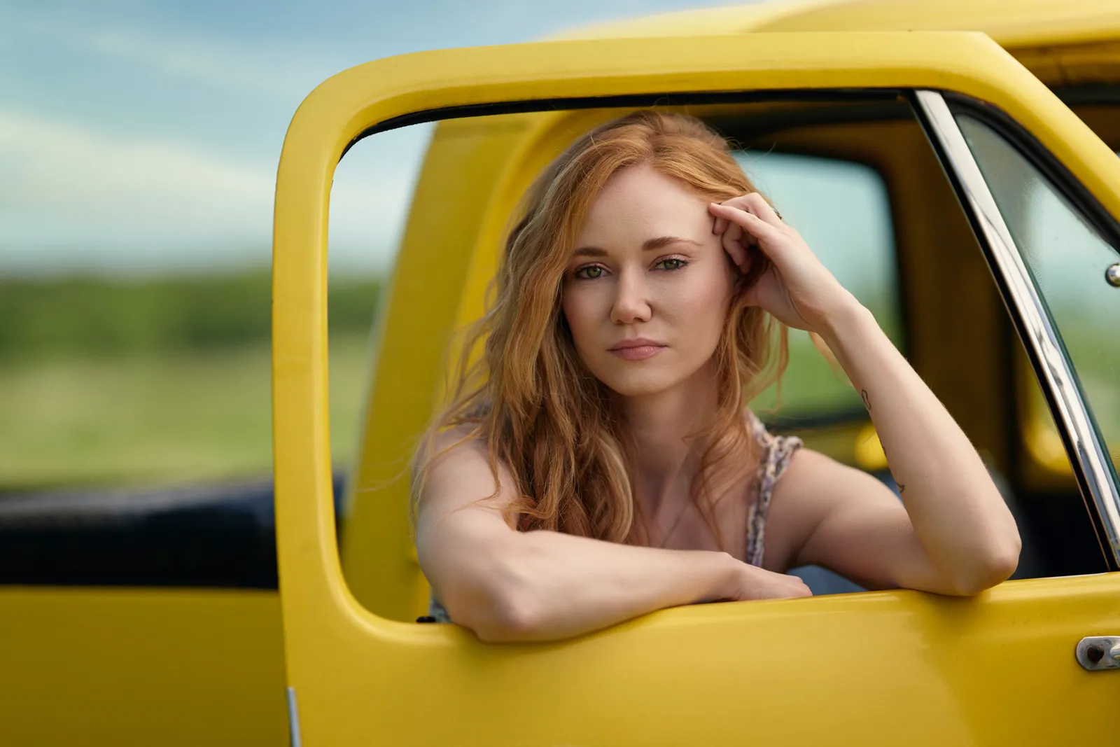 Portrait of a model leaning out of a yellow truck window