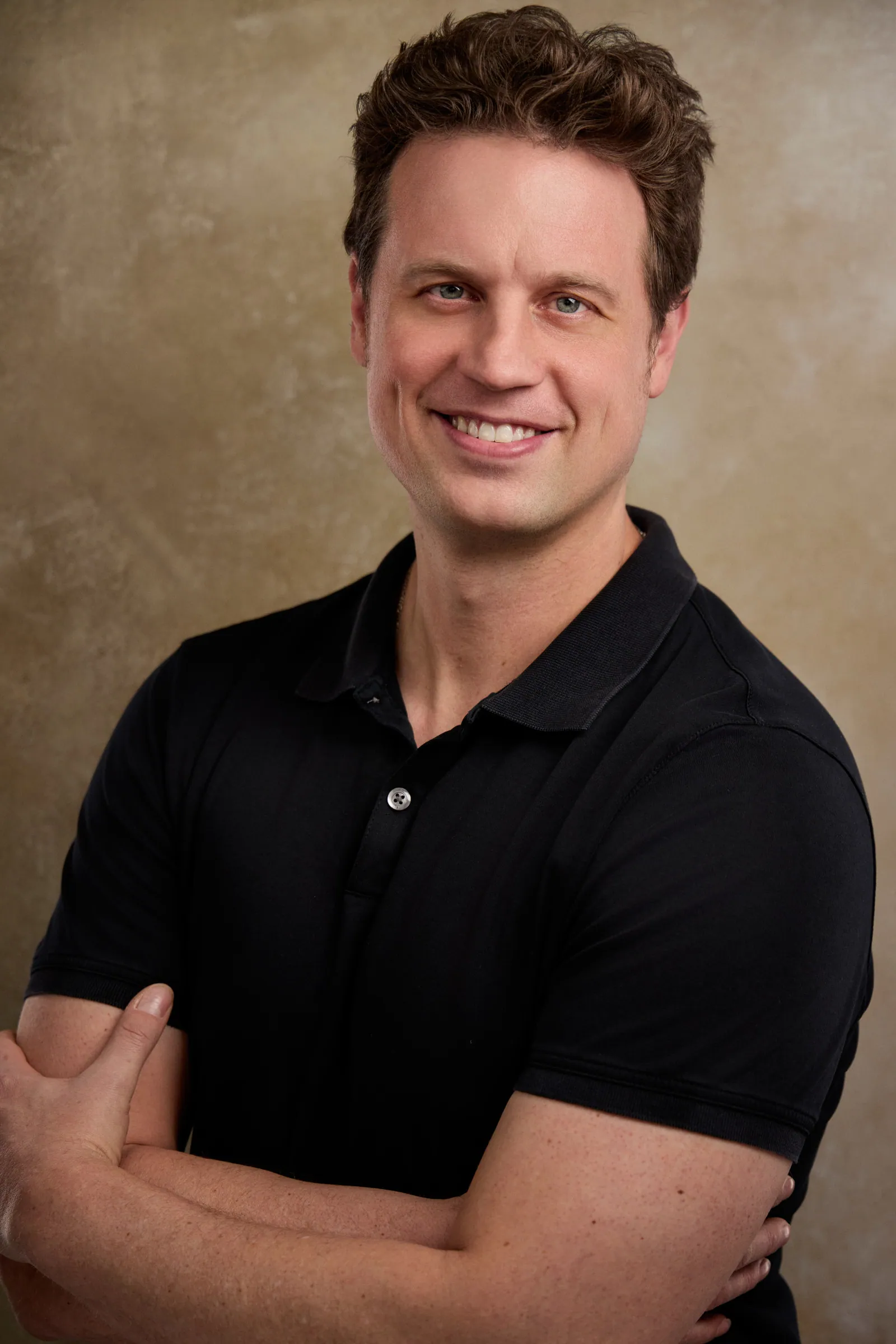 portrait of a man in a black shirt smiling