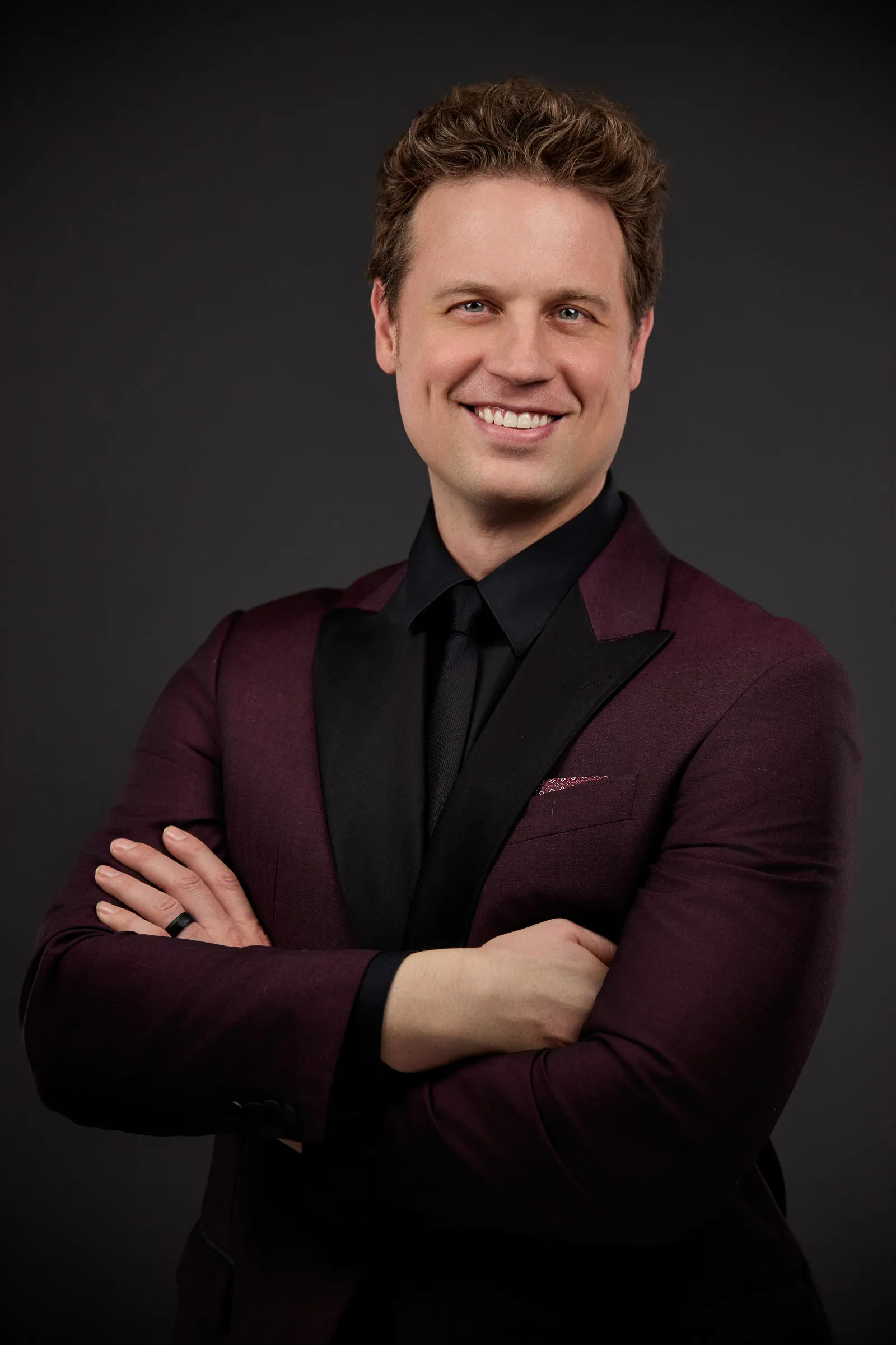 man in Burgundy business suit smiling